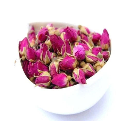 Loose rose tea buds in a white bowl, bright pink and magenta petals