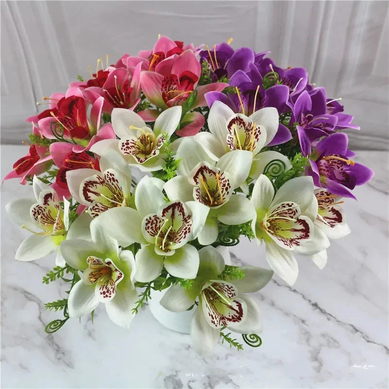 Artificial flower bundle with pink, purple, and white faux orchids with green leaves