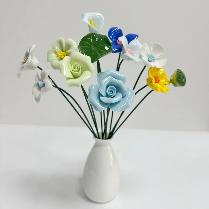 Ceramic flower plant stakes set with white, blue, and yellow blossoms on green stems
