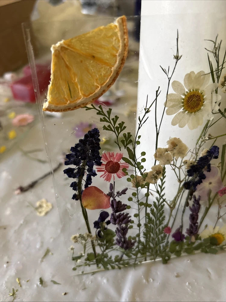 Dried flower frame with daisies and purple lavender blossoms on clear glass
