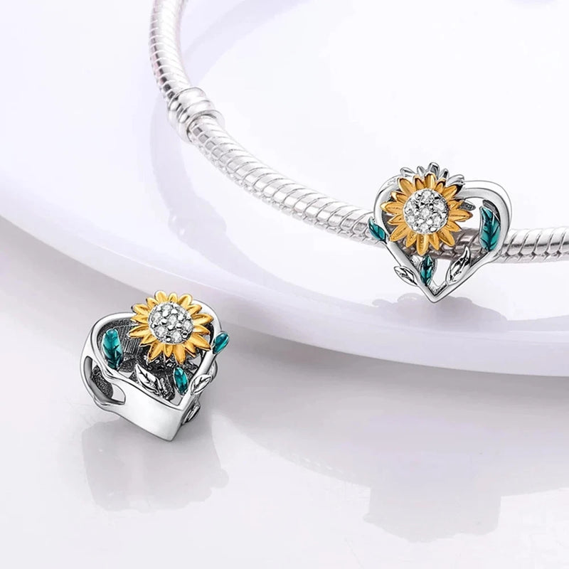 Sterling silver heart charm with sunflower center and blue accents on open clip