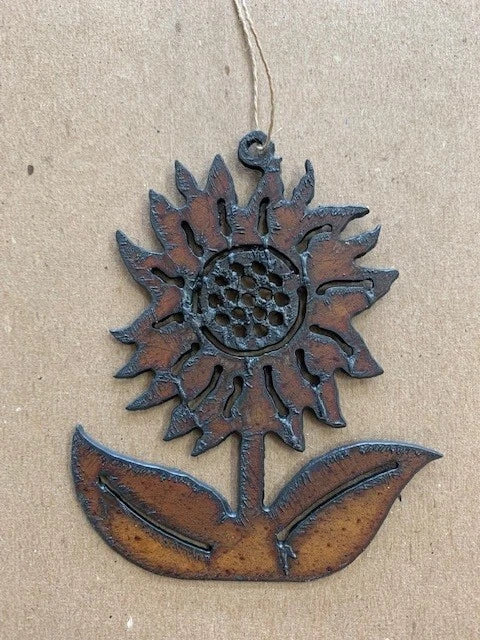 Rust-brown cut iron sunflower ornament with hanging loop and leaf accents