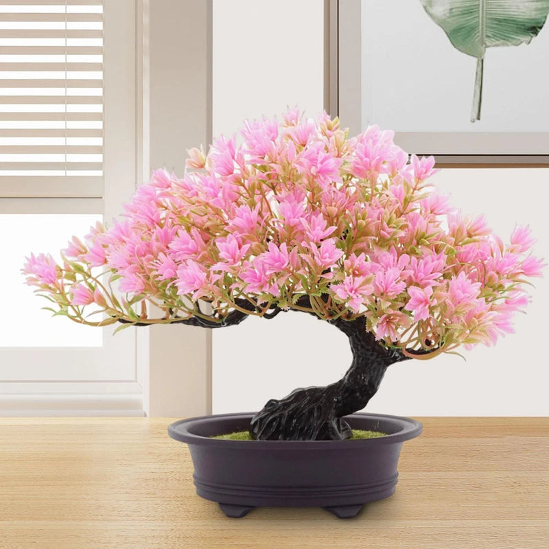 Artificial pink flowering bonsai tree in dark pot with textured trunk