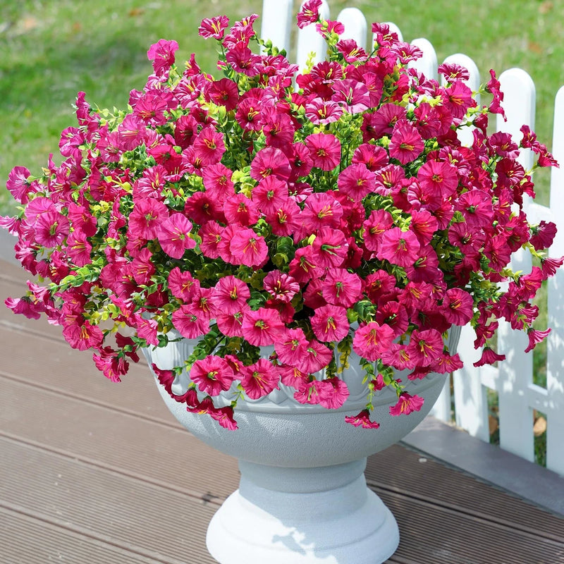 Artificial pink flower bouquet with green stems in white planter bowl