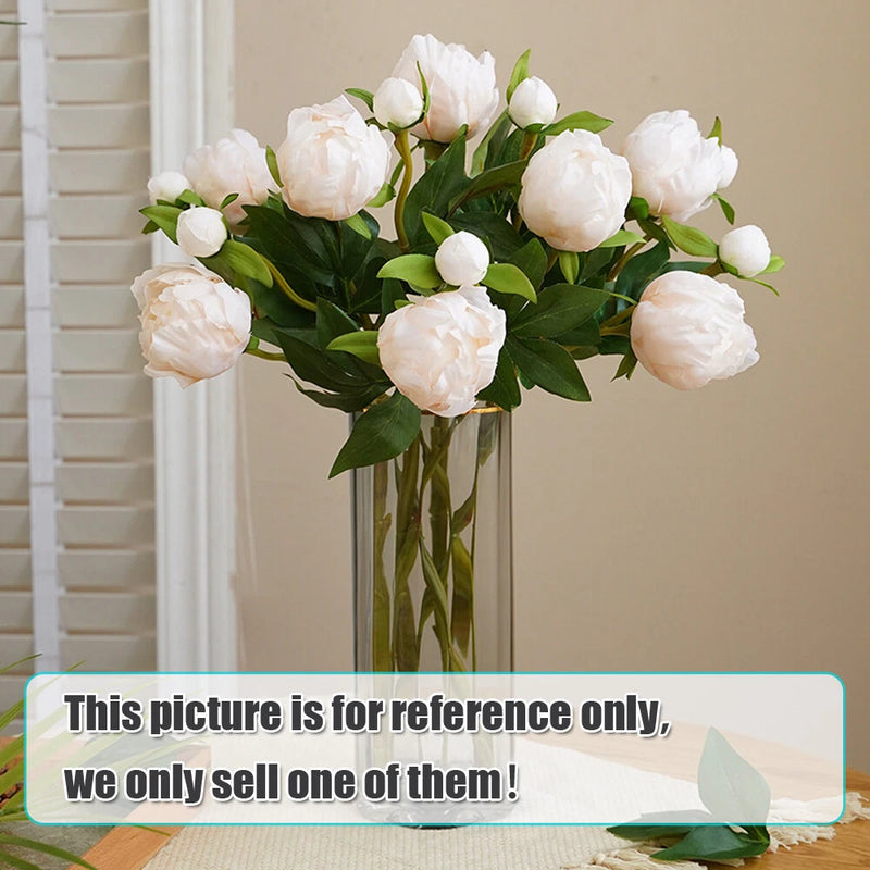 Artificial peony flower bouquet with white blooms and green leaves in a clear vase