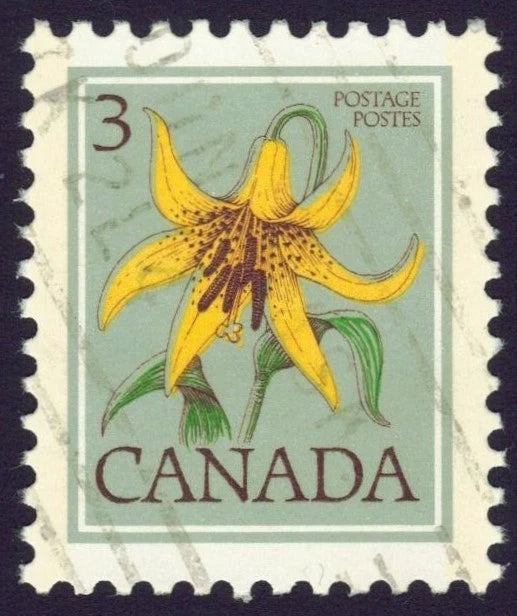 Used Canada postage stamp with yellow lily flower illustration, green leaves