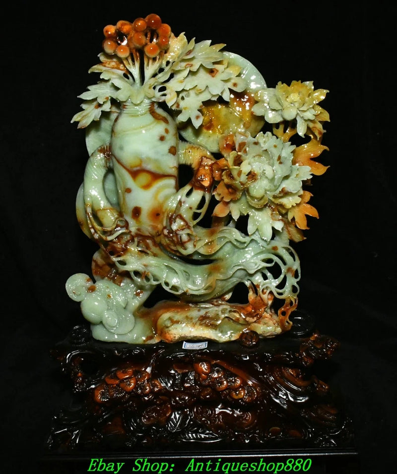 Carved jade ruyi statue with peony flowers, orange bead accents, on dark base
