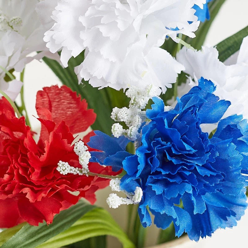 Patriotic artificial floral bush with red & blue carnations, white gypsophila, green leaves