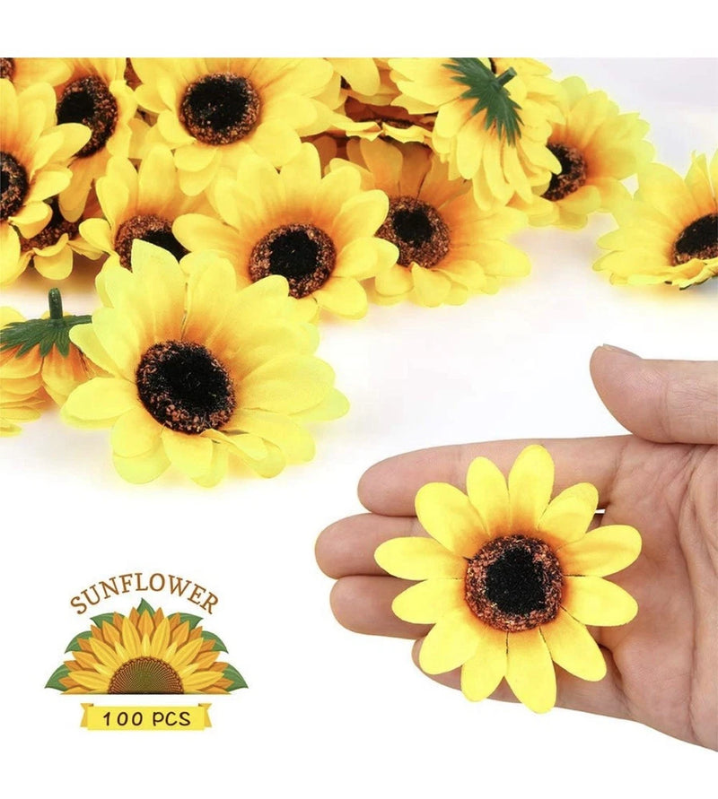 Mini artificial sunflower head, yellow petals with dark brown center, held in hand