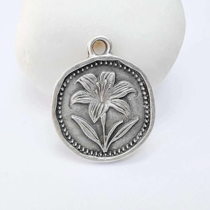 Antique silver lily flower pendant charm, round with dotted border and top loop bail