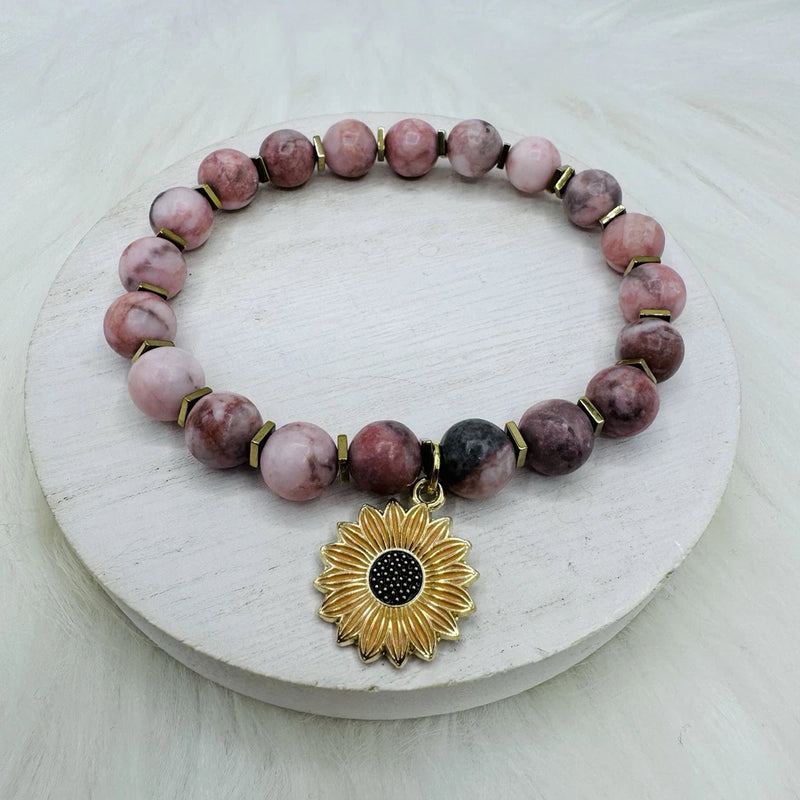 Pink beaded bracelet with sunflower charm, marbled pink beads and gold spacers with black bead