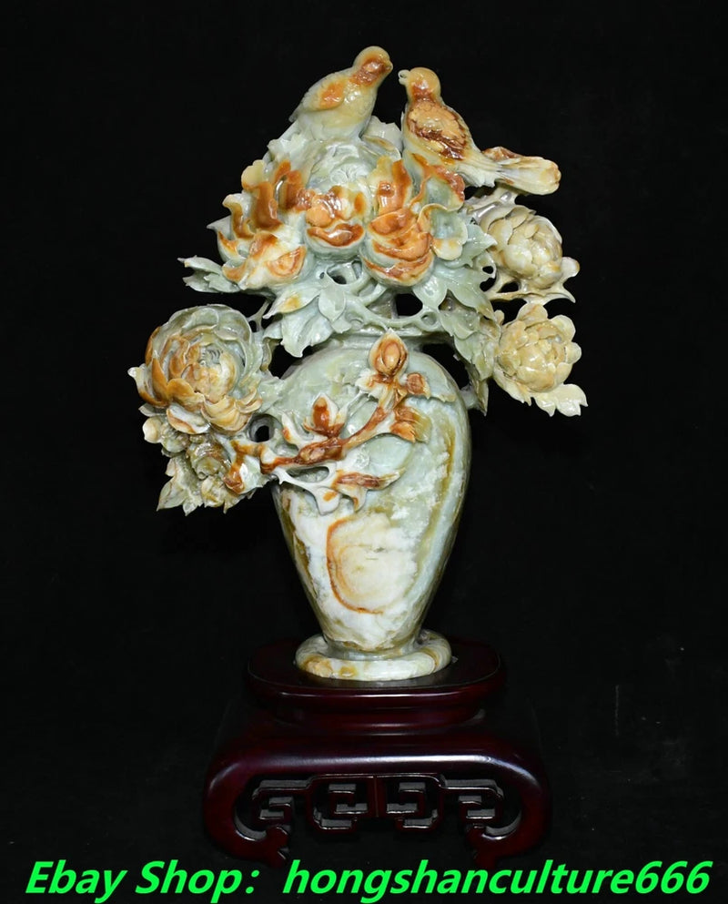 Carved jade-style bottle vase with peony flowers and small birds on dark stand