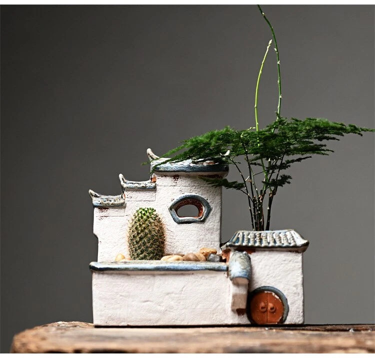 Ceramic house-style flower pot with stacked tiers and small circular door planter