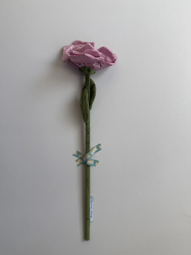 Iridescent pink peony flower with green stem and small decorative ribbon at base