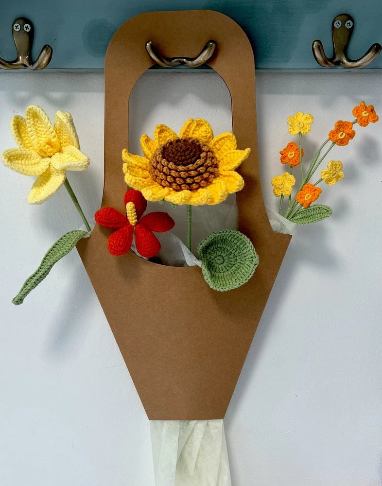 Handmade crochet flower bouquet in brown paper handle holder with yellow and red blooms