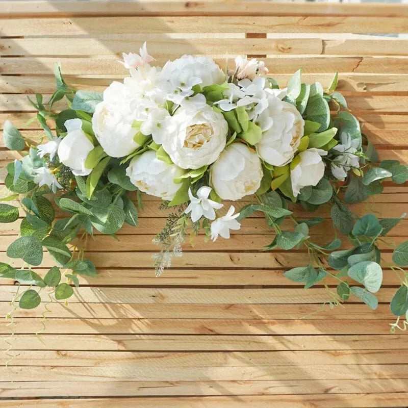 Artificial flower wreath with white peony and rose blooms, green leaves, and trailing accents