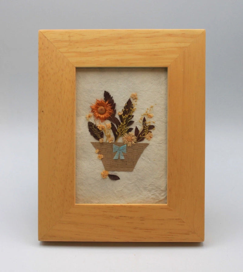 Framed pressed dried flowers artwork on natural paper in light wood frame