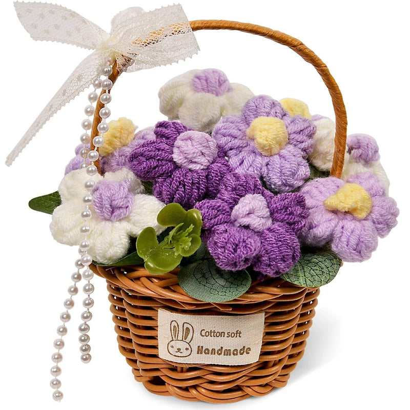 Handmade crochet flower bouquet in wicker basket, purple and cream blooms with green leaves, pearls