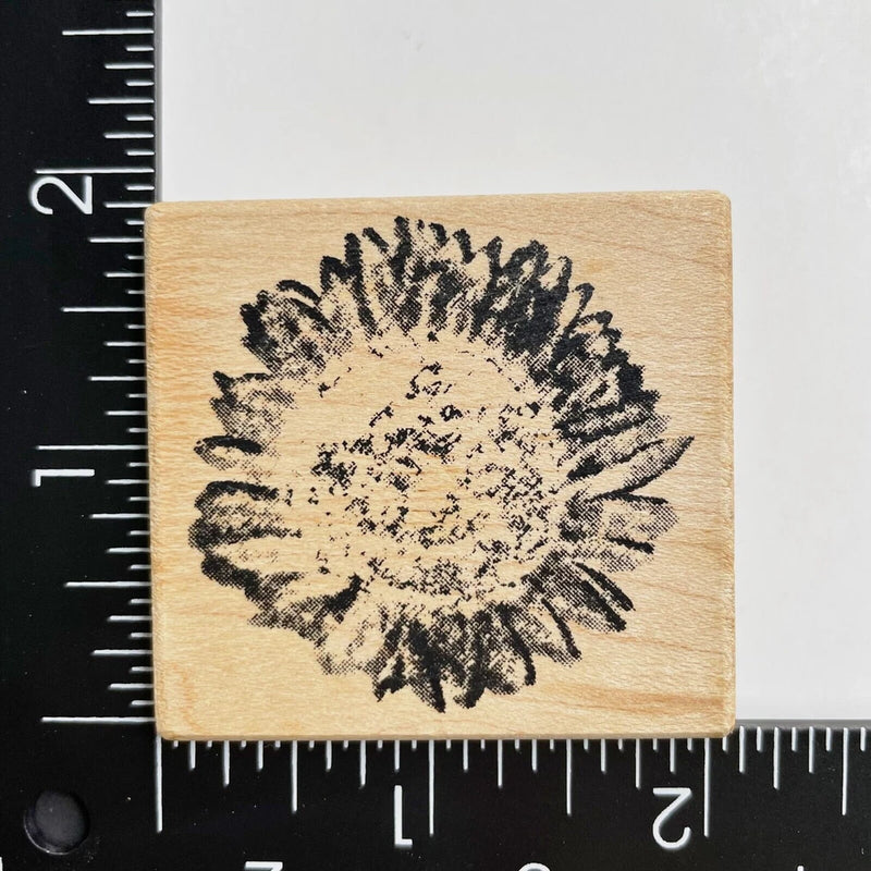 Wood-mounted rubber stamp with distressed sunflower blossom in black ink