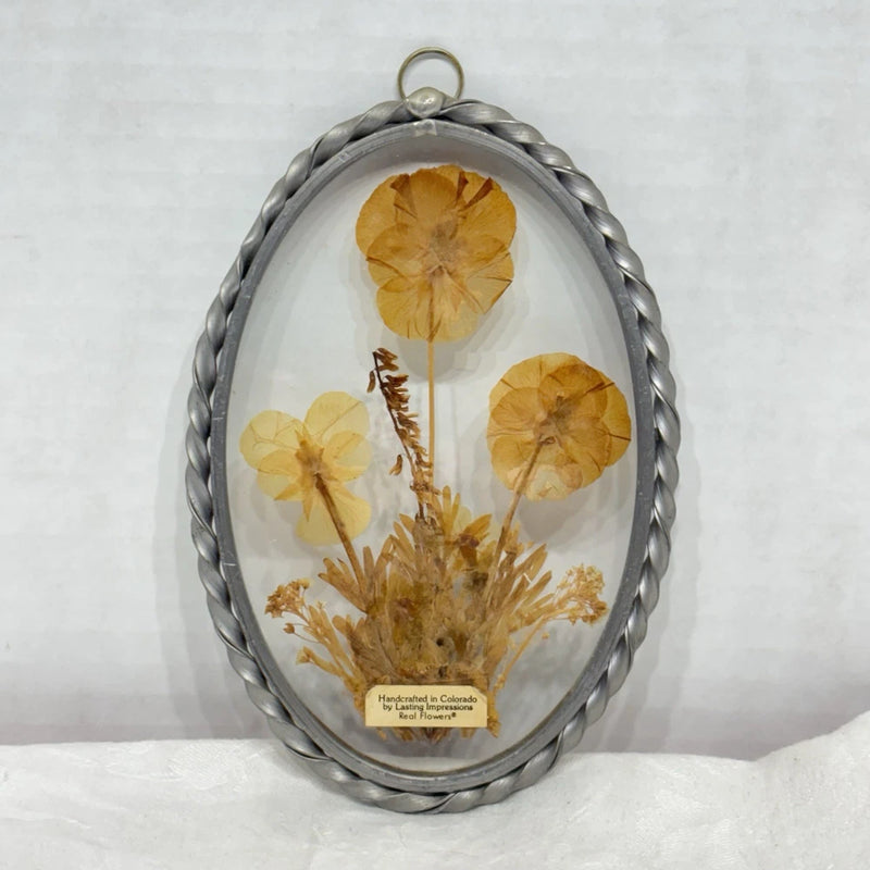 Twisted pewter framed glass suncatcher with pressed dried flowers in oval pendant