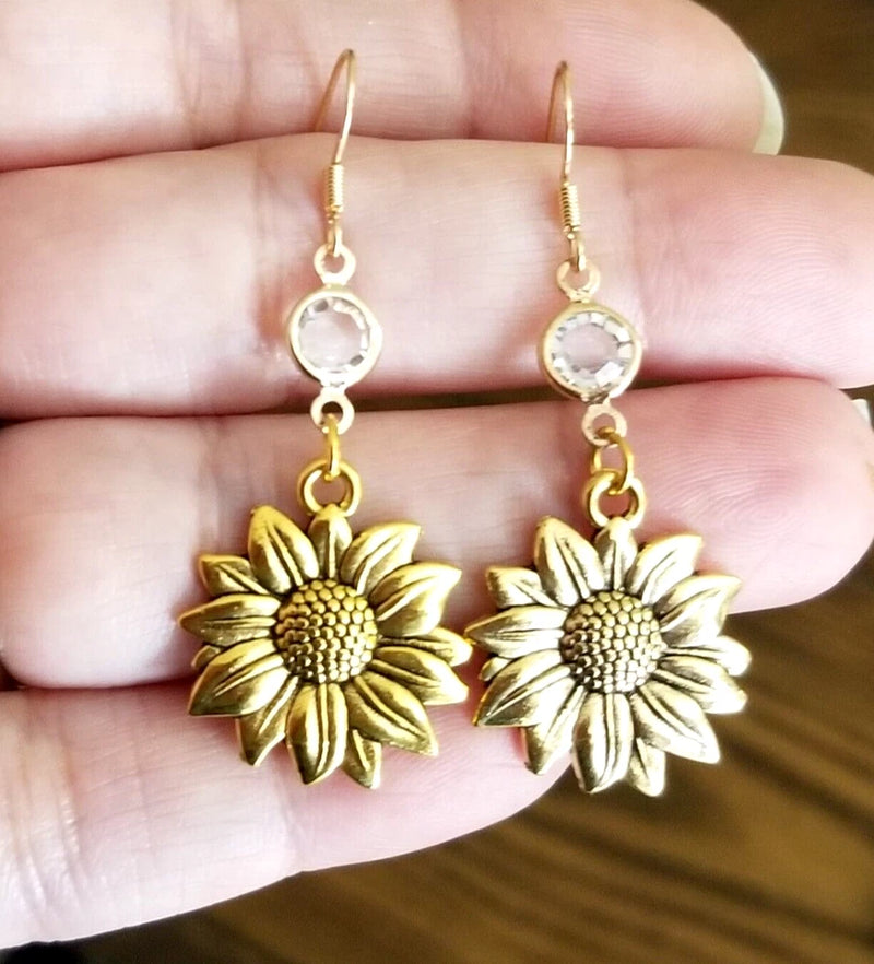 Gold sunflower dangle earrings with round textured centers and small link chains