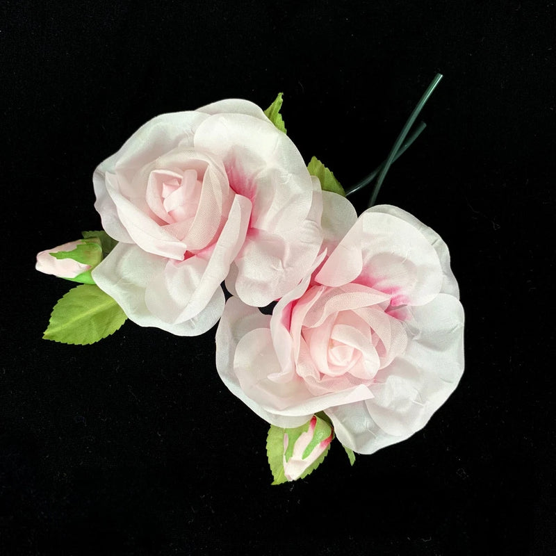 Faux fabric rose flowers, white petals with pink centers and green leaves