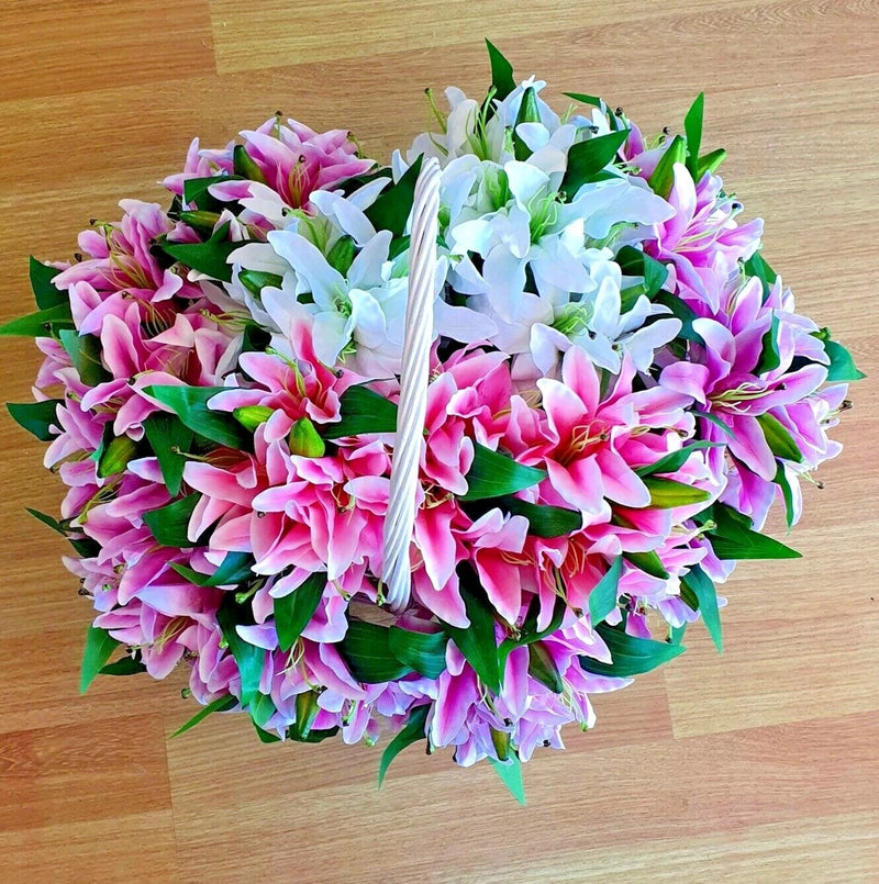 Artificial lily bouquet with 7 pink and white blooms and green leaves, tied with ribbon