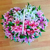 Artificial lily bouquet with 7 pink and white blooms and green leaves, tied with ribbon