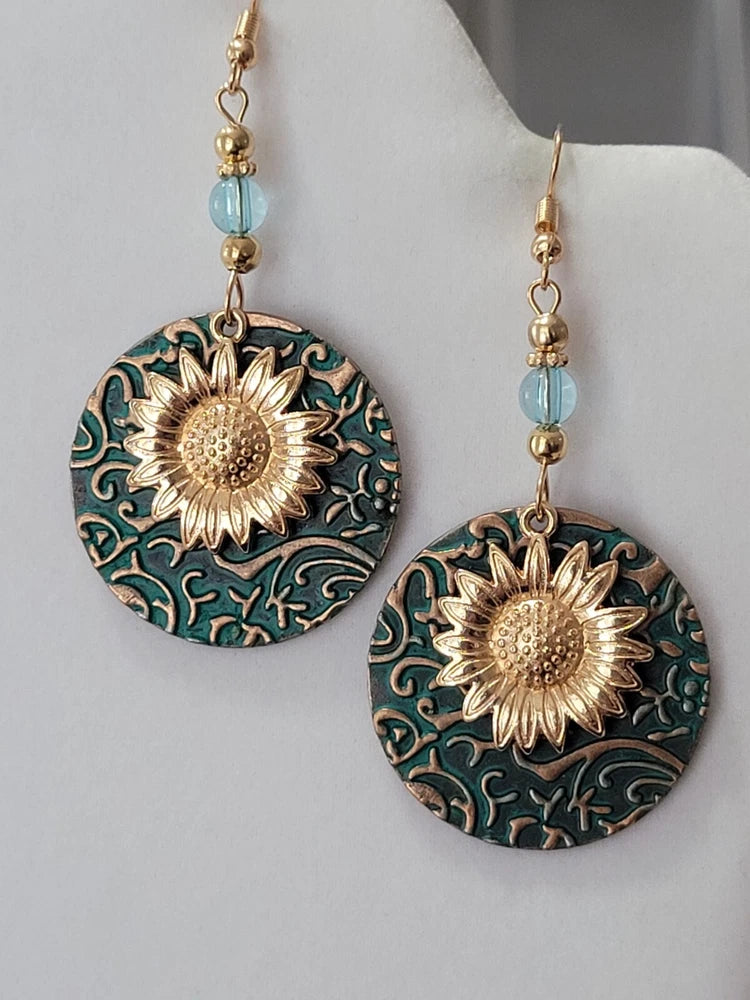 Gold-tone dangle earrings with turquoise patterned discs and sunflower centers, pierced