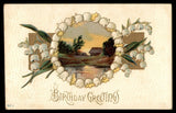 Birthday greetings postcard with lily of the valley wreath around a landscape and text