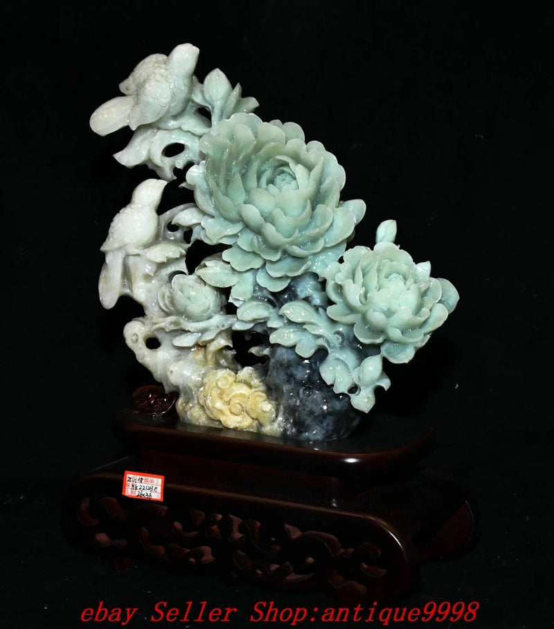 Carved jade-style statue with peony blossoms and bird-beast figurine on dark base