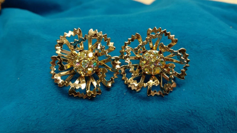 Gold tone rhinestone floral clip earrings with starburst flower design