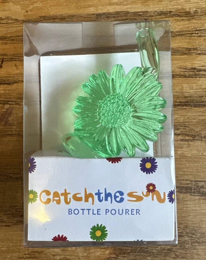 Green flower-shaped bottle pourer in clear retail box with logo card