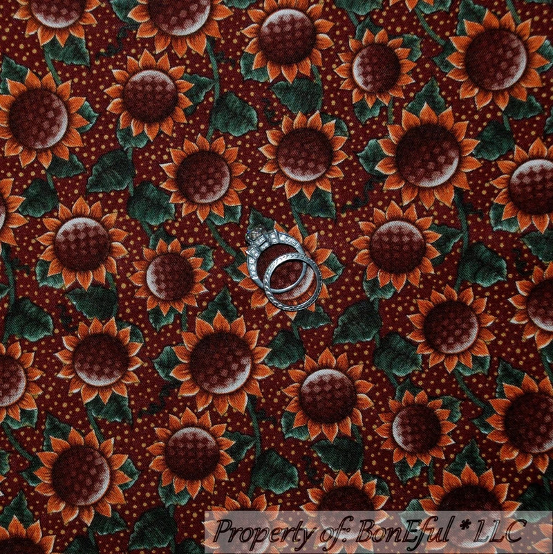 Maroon cotton quilt fabric with large sunflower print and green leaves, floral pattern