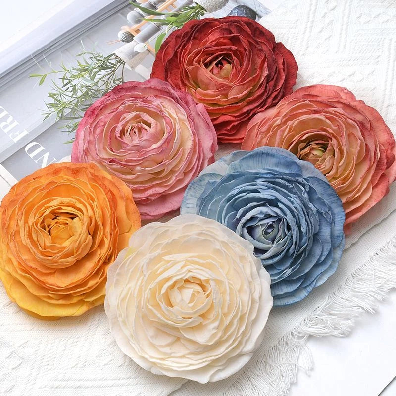Artificial rose flower heads, red pink orange blue and white, layered fabric petals.