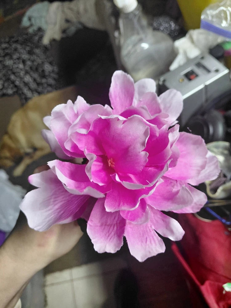 Faux peony flower with layered pink and magenta petals on a red stem