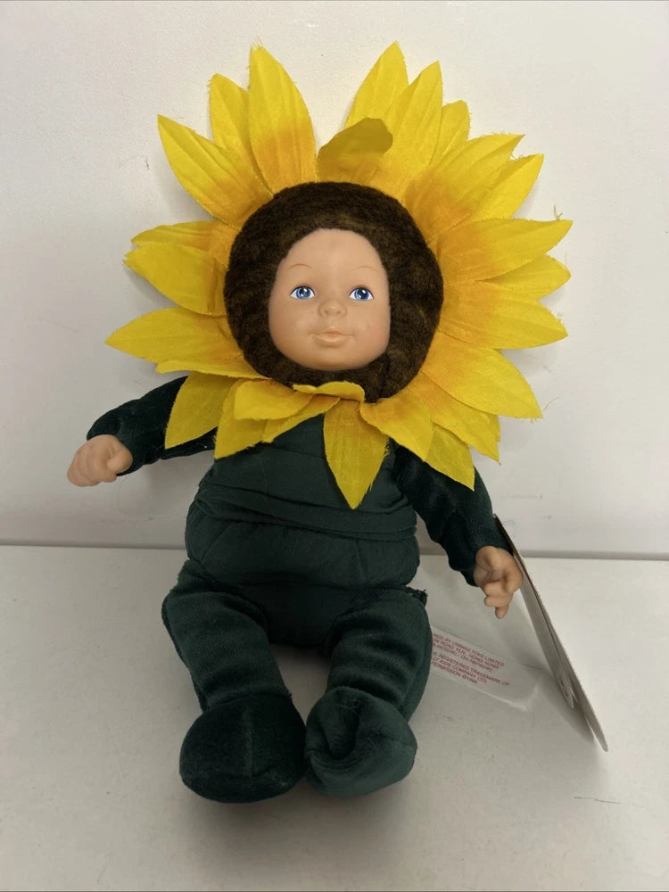 Plush baby doll with yellow sunflower headpiece, black hair, dark green outfit