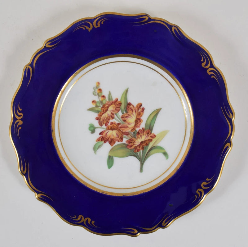 Antique porcelain plate with cobalt blue rim, gold scroll edge, and carnation bouquet center