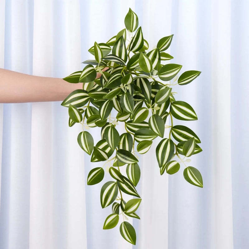 Faux hanging plant with cascading green leaves in a white planter