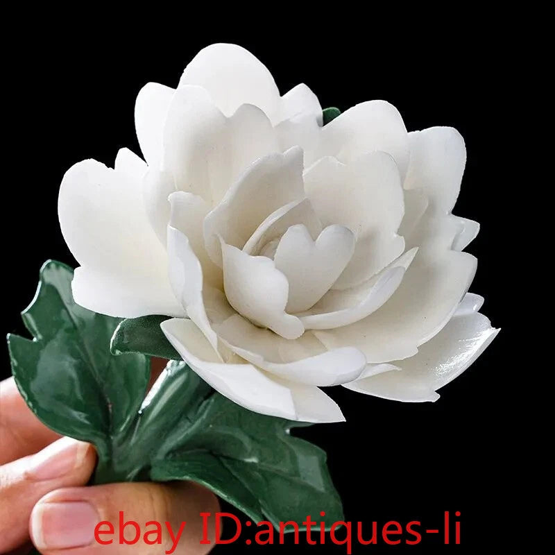White porcelain peony flower with layered petals and green leaf accents