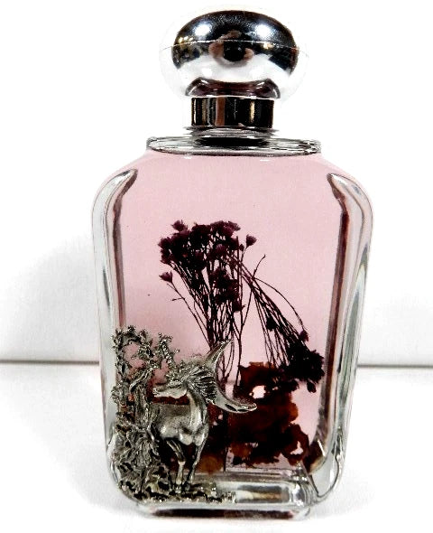 Glass herbarium bottle with unicorn figurine and dried flowers inside