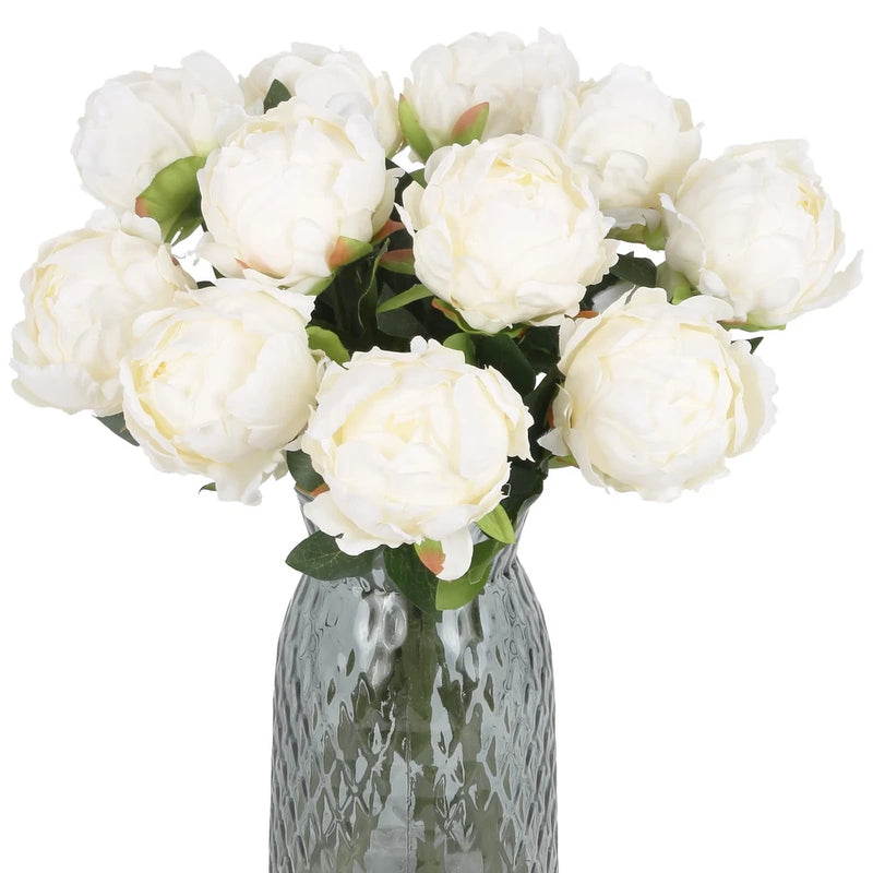 Set of faux white silk peony flowers with green leaves in textured gray vase