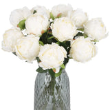 Set of faux white silk peony flowers with green leaves in textured gray vase