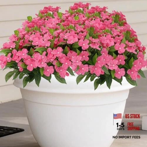 Artificial impatiens flower bouquet with faux silk blooms and green leaves in a white pot