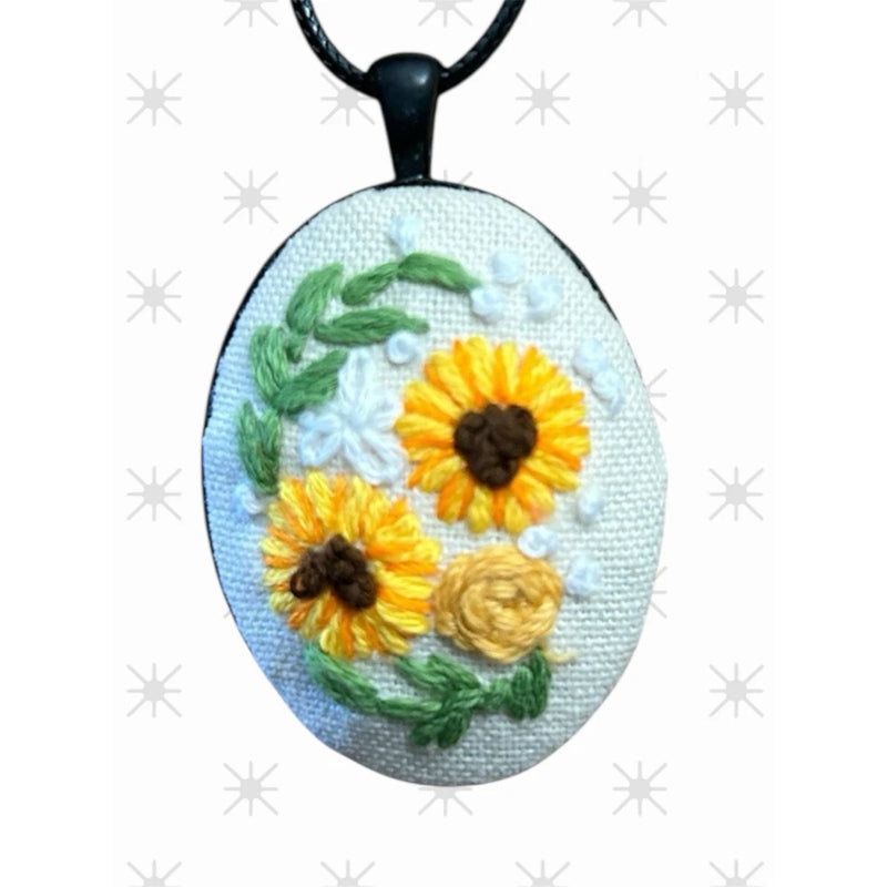 Embroidered sunflower pendant necklace with oval light-blue floral design and black cord