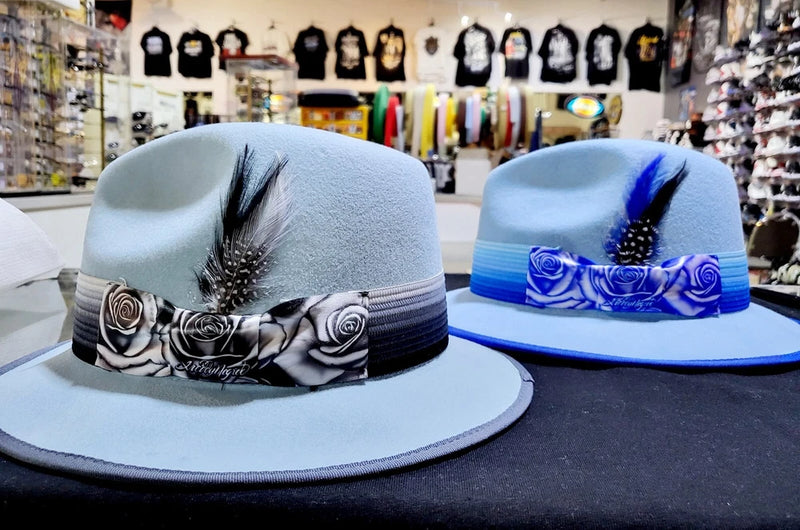 Light blue wool lowrider brim fedora hat with rose-printed band and feather accent