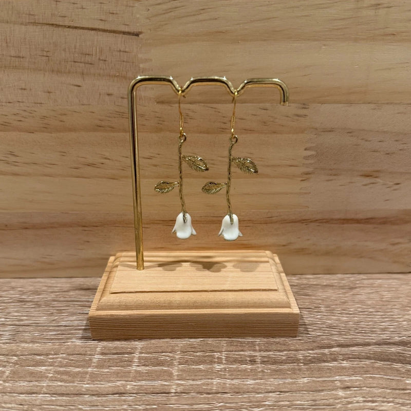Gold-tone vine leaf drop earrings with small white flower dangles