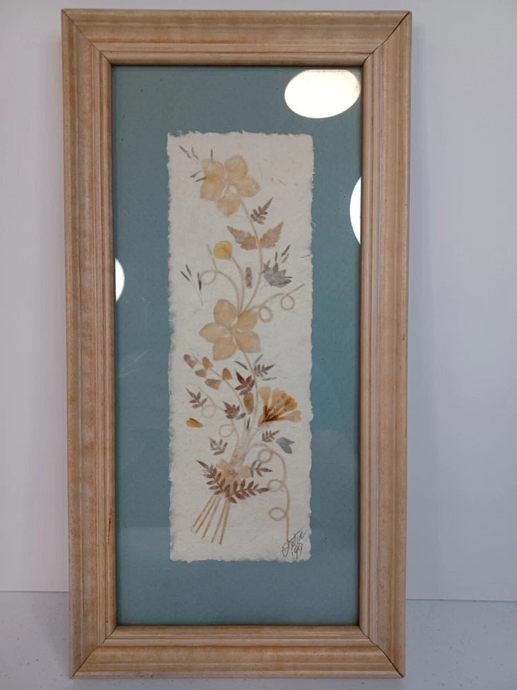 Framed pressed flower artwork on handmade paper with vintage floral silhouettes