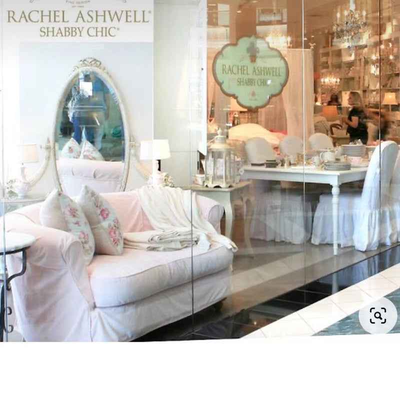 Pale pink velvet sofa with floral embroidered cushions in a shabby chic style