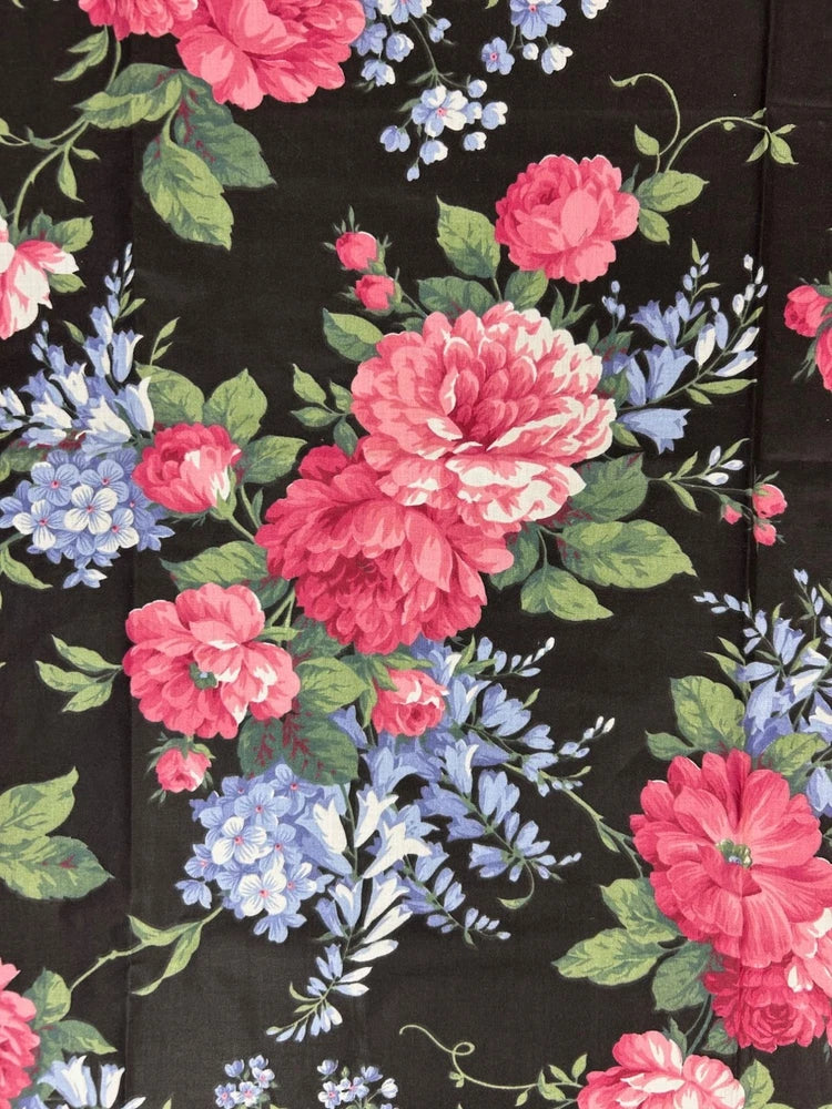 Floral chintz fabric with pink and blue roses on dark background